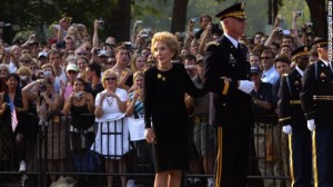 Former first lady Nancy Reagan glances over her shoulder as she is escorted to the casket of former U.S. President Ronald Reagan by Sgt. Galen Jackman while it is transferred from a hearse to a horse-drawn caisson in front of the White House.