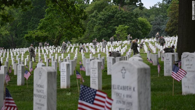 Members of the Army's 3rd Infantry Regiment -- also known as the "Old Guard" -- plant flags at tombstones in Arlington National Cemetery in Washington on Thursday, May 23, ahead of Memorial Day.
