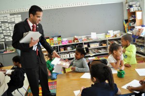 Providence Mayor Angel Taveras hands out books to young students during a school visit.