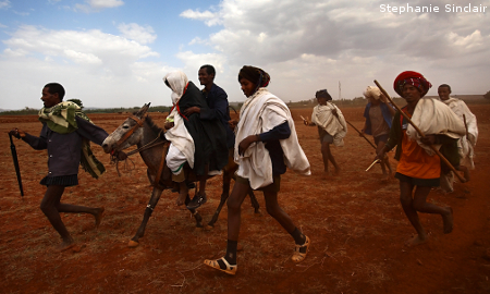 Leyualem, 14, is wisked away on a mule by her new groom and groomsmen in Ethiopia.