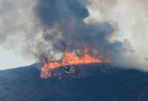 A Ventura County Fire Department helicopter heads to make a water drop on the wildfire in Pt. Mugu State Park on May 3, 2013. Photo credit: Kevork Djansezian/Getty Images